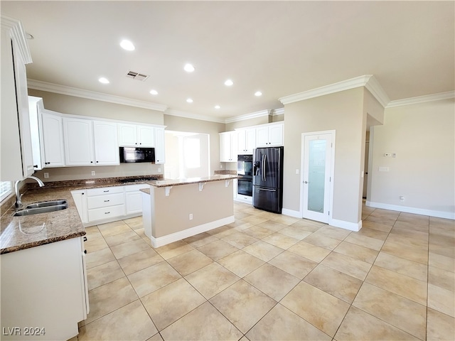 kitchen featuring dark stone counters, sink, black appliances, and ornamental molding