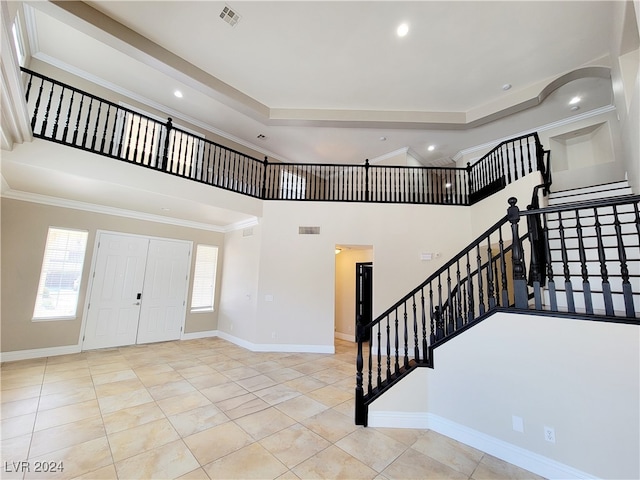 tiled entrance foyer featuring a high ceiling and ornamental molding