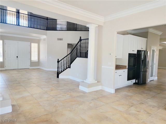 entrance foyer with ornate columns and ornamental molding