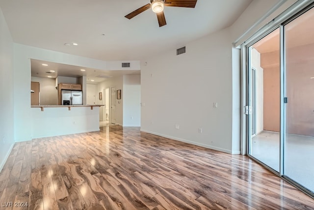 unfurnished living room featuring ceiling fan and light hardwood / wood-style flooring