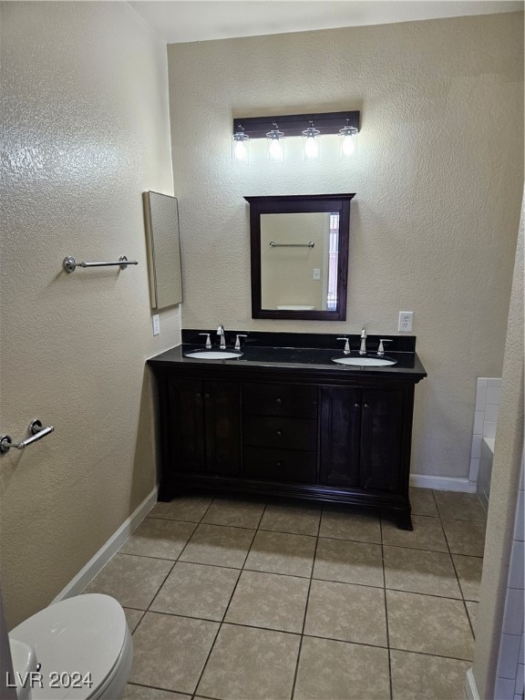 bathroom with tile patterned flooring, vanity, toilet, and a bathing tub