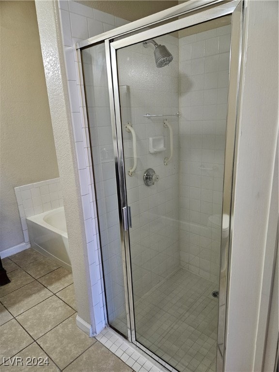 bathroom with independent shower and bath and tile patterned flooring