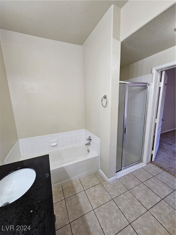 bathroom featuring a textured ceiling, vanity, tile patterned floors, and plus walk in shower