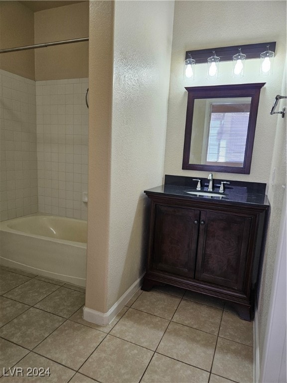 bathroom featuring tiled shower / bath, vanity, and tile patterned floors