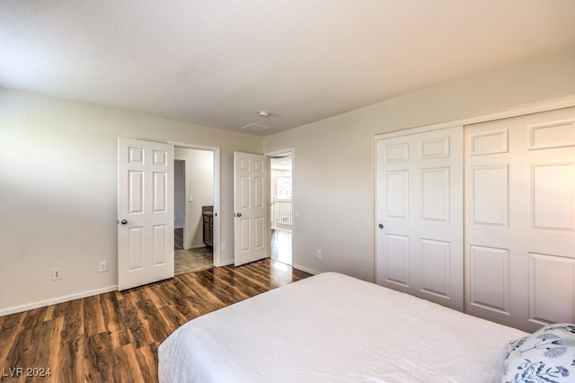 bedroom with dark wood-type flooring and a closet