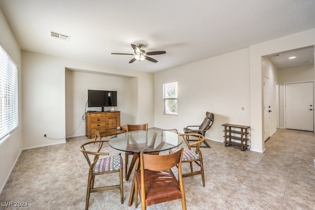 tiled dining space with ceiling fan