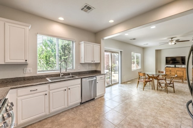 kitchen with appliances with stainless steel finishes, sink, white cabinetry, a wealth of natural light, and ceiling fan