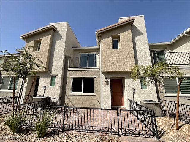 townhome / multi-family property featuring a balcony and central air condition unit