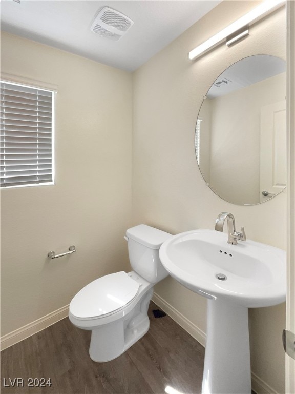 bathroom with toilet and hardwood / wood-style floors