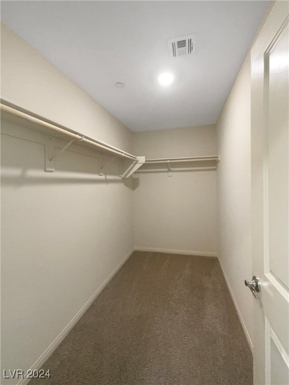 walk in closet featuring dark colored carpet