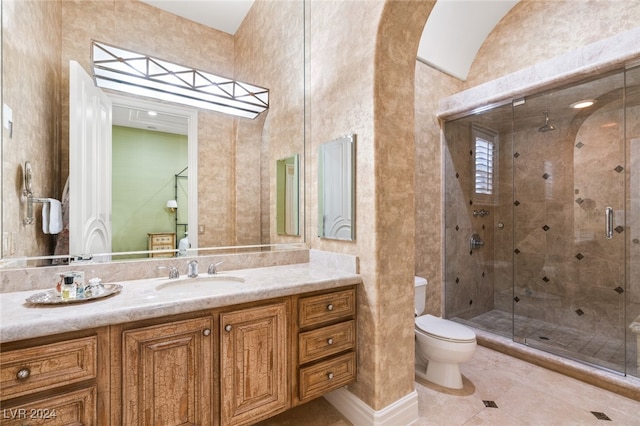 bathroom featuring tile patterned floors, toilet, a shower with door, and vanity