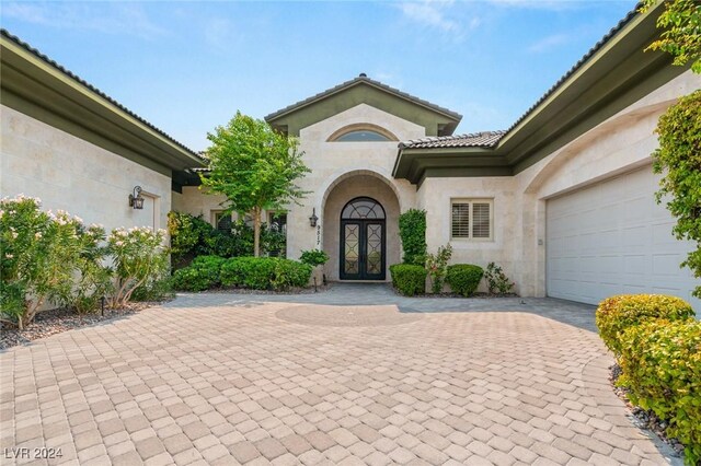 doorway to property featuring a garage and french doors