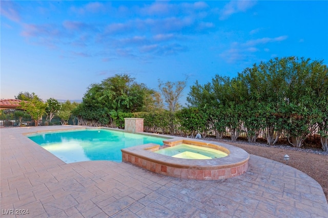 view of pool featuring a patio area and an in ground hot tub