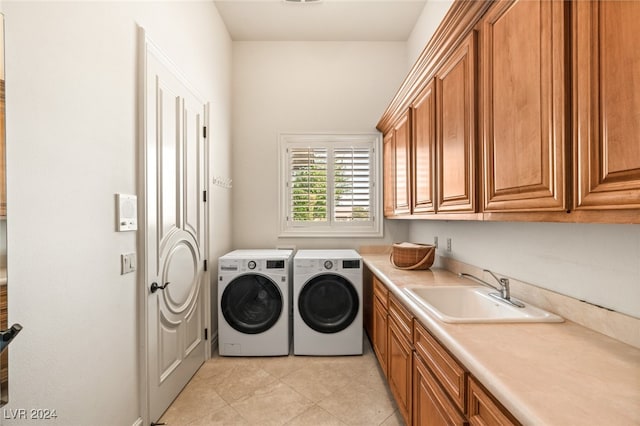 washroom with light tile patterned floors, cabinets, independent washer and dryer, and sink