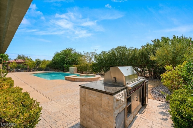 view of pool with exterior kitchen, area for grilling, and a patio area