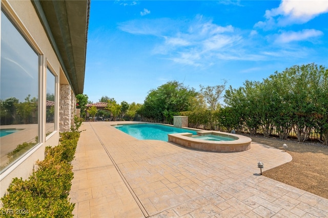 view of pool with a patio area and an in ground hot tub