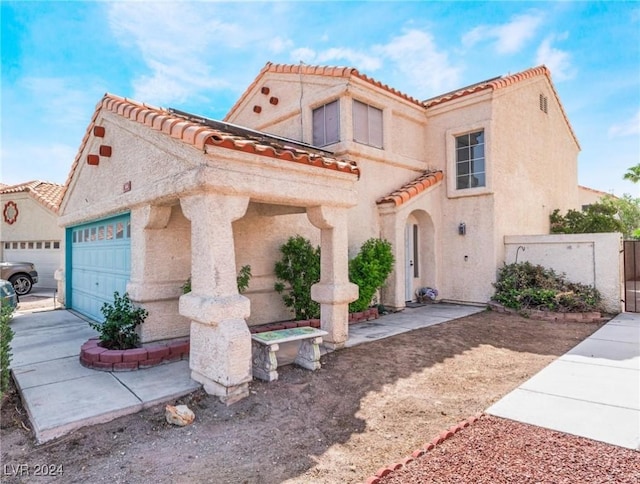 mediterranean / spanish home with a gate, driveway, an attached garage, stucco siding, and a tile roof