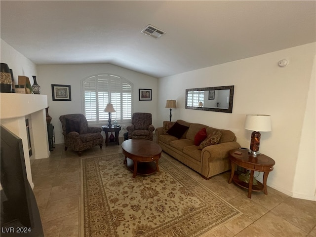 tiled living room featuring vaulted ceiling