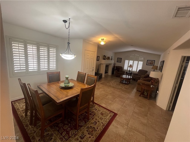 dining room with light tile patterned floors and vaulted ceiling