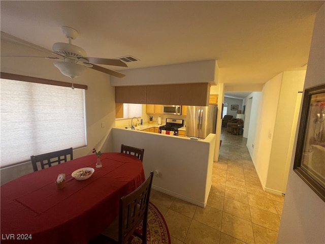 dining room featuring ceiling fan, light tile patterned floors, and sink