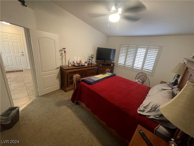 bedroom with light carpet, lofted ceiling, ceiling fan, and a textured ceiling