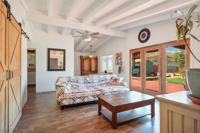 living area featuring a barn door, wood finished floors, vaulted ceiling with beams, ceiling fan, and french doors