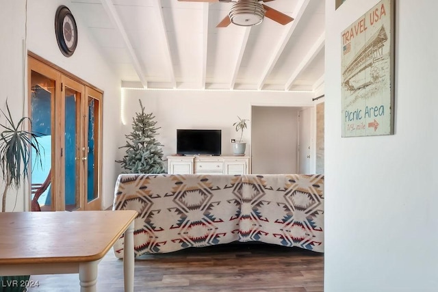 living area featuring beamed ceiling, a ceiling fan, and wood finished floors