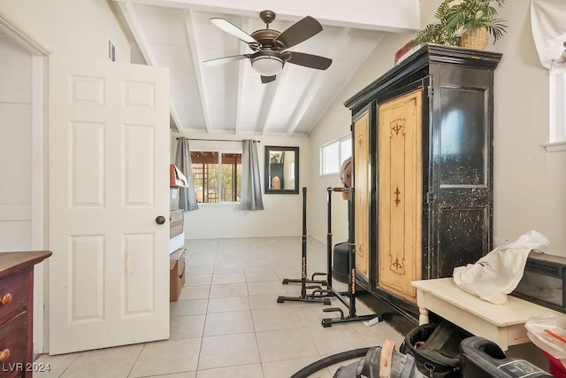 workout room featuring light tile patterned flooring, lofted ceiling, and ceiling fan