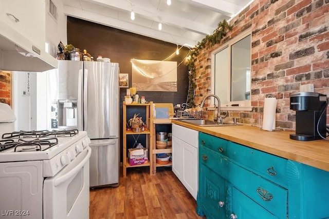 kitchen with under cabinet range hood, white gas range, wood finished floors, a sink, and butcher block countertops