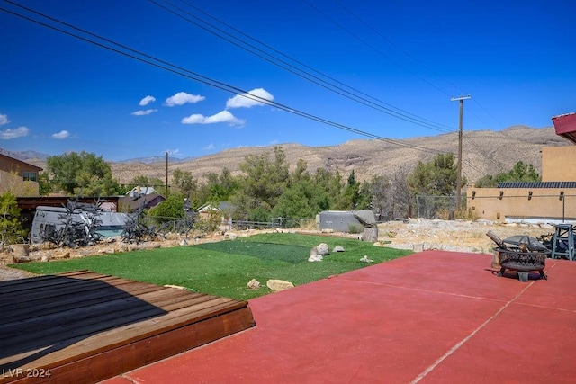 view of yard featuring a patio area, a fenced backyard, a fire pit, and a mountain view