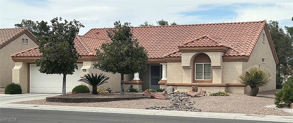 mediterranean / spanish-style house with a garage