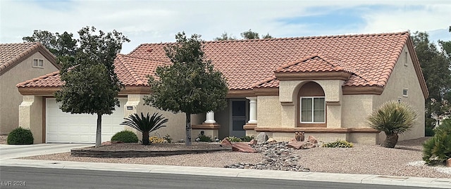 mediterranean / spanish-style house with a garage