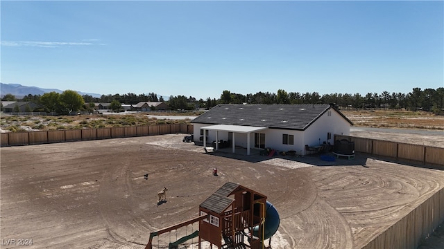 back of property featuring a playground, a patio, a mountain view, and central air condition unit