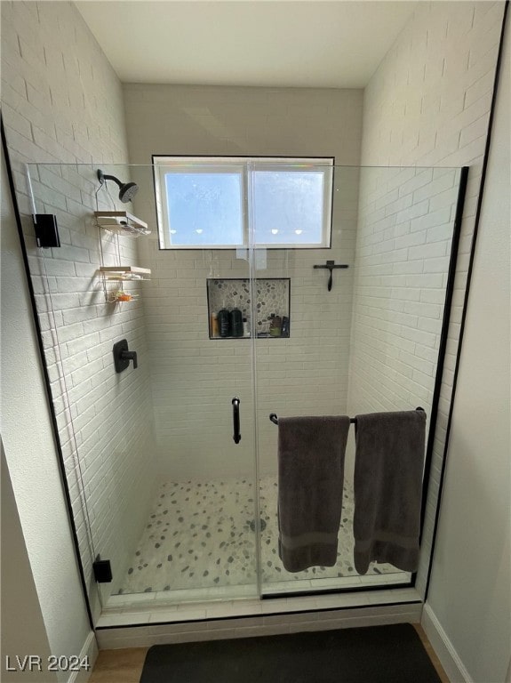 bathroom featuring a shower with door