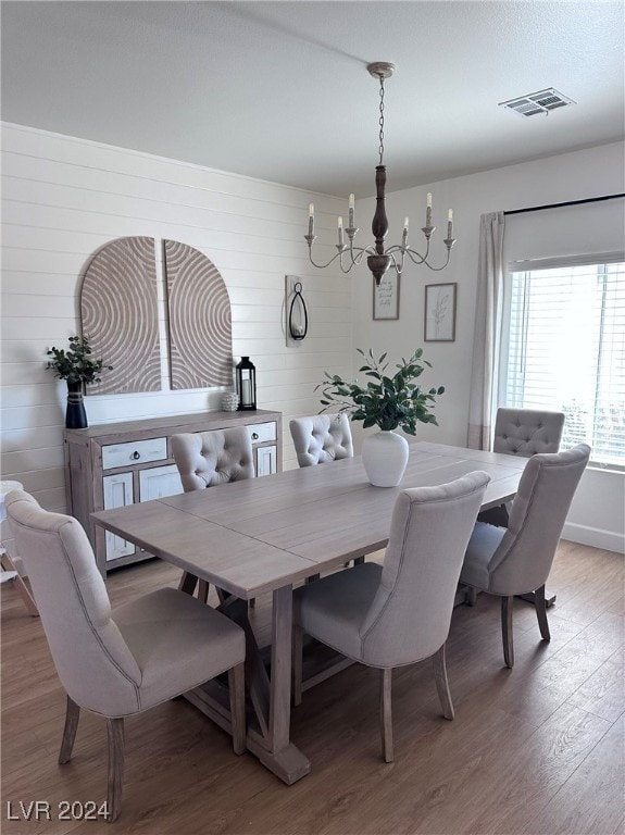 dining area with an inviting chandelier and hardwood / wood-style floors