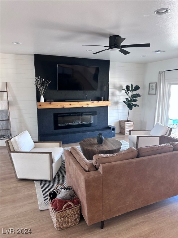 living room with wood-type flooring and ceiling fan