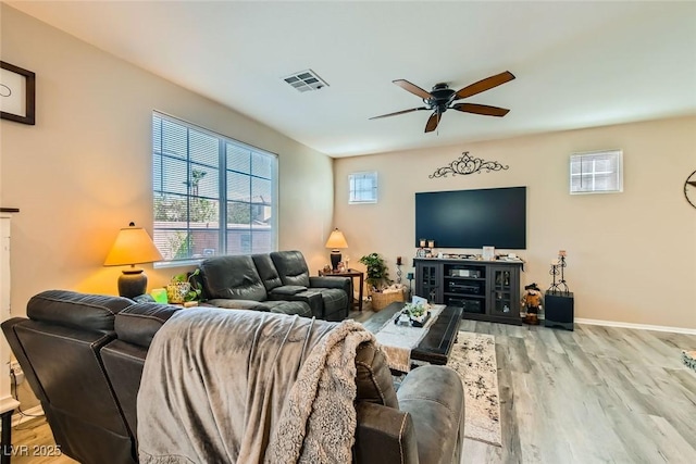 living room with a healthy amount of sunlight, ceiling fan, and light hardwood / wood-style flooring