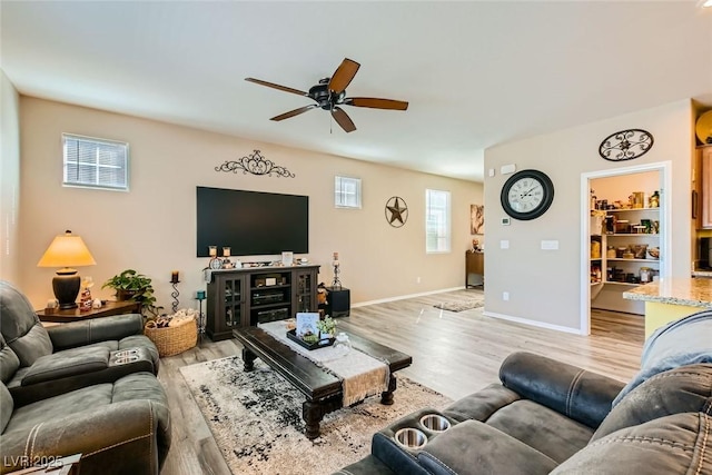 living room featuring ceiling fan and light hardwood / wood-style flooring