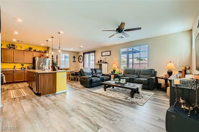 living room featuring ceiling fan and light hardwood / wood-style floors