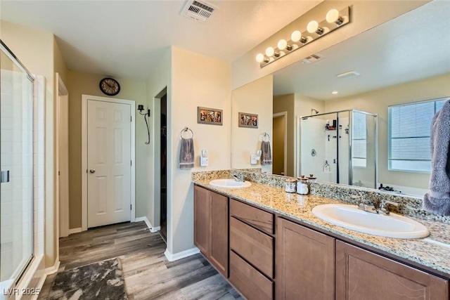 bathroom featuring walk in shower, wood-type flooring, and vanity