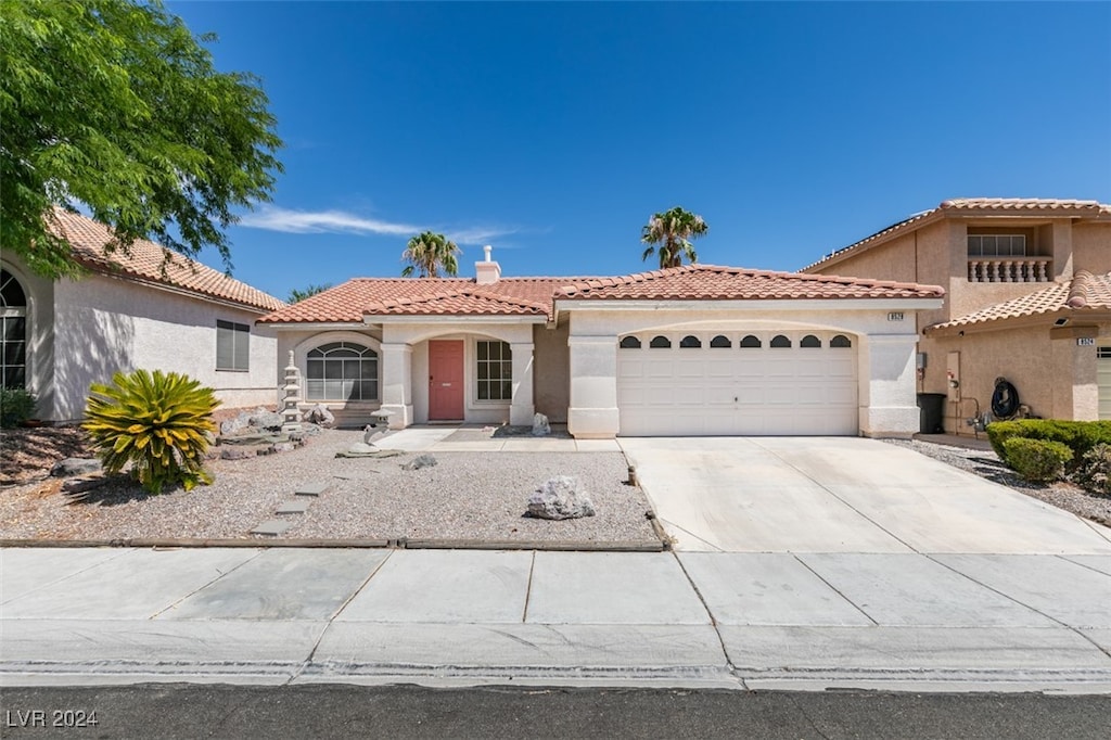 mediterranean / spanish home featuring a garage