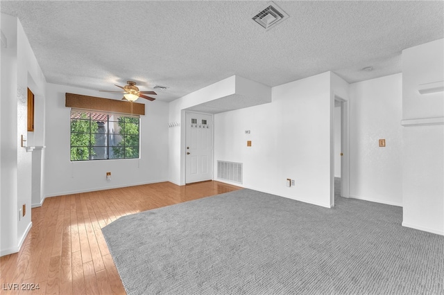 unfurnished room featuring ceiling fan, hardwood / wood-style floors, and a textured ceiling