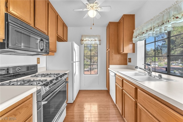 kitchen featuring range with gas stovetop, light wood-type flooring, sink, white dishwasher, and ceiling fan