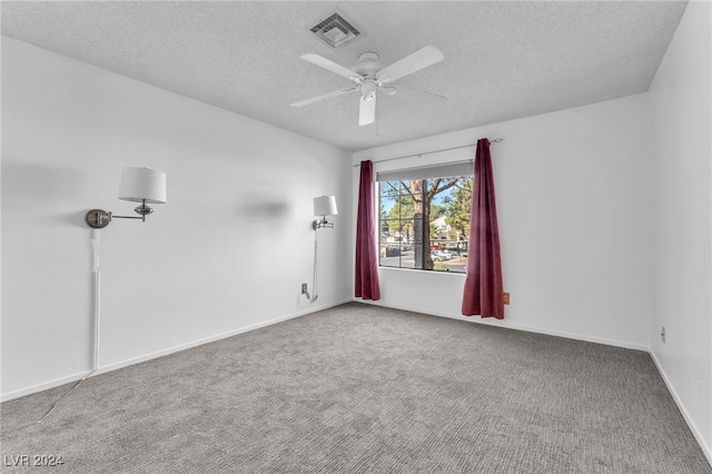 empty room with a textured ceiling, carpet, and ceiling fan