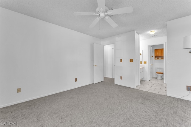 unfurnished room featuring ceiling fan, light colored carpet, and a textured ceiling