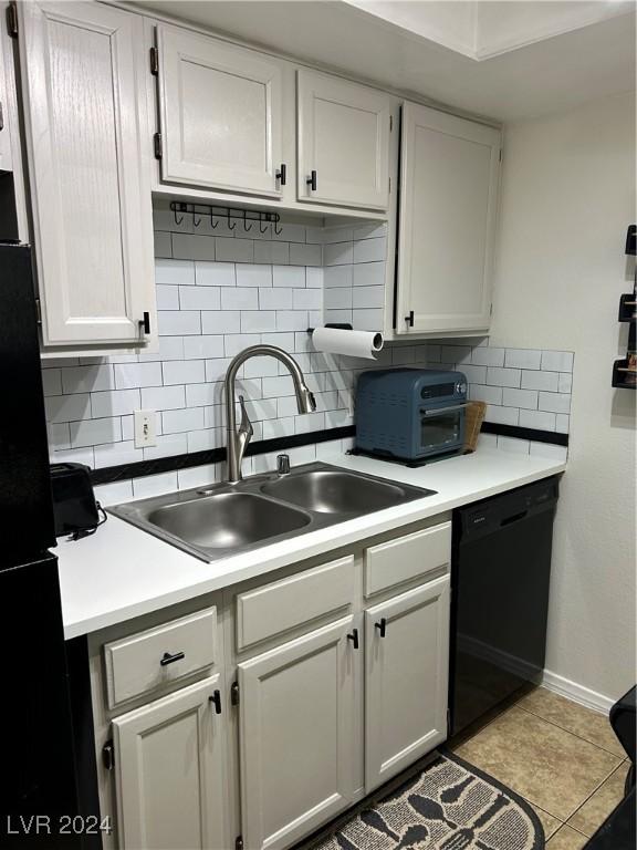 kitchen featuring black appliances, white cabinetry, light tile patterned flooring, and sink