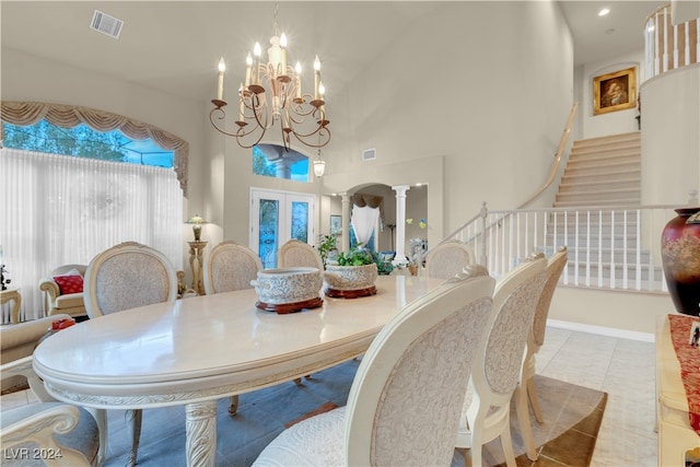 dining area with high vaulted ceiling, decorative columns, light tile patterned floors, and an inviting chandelier