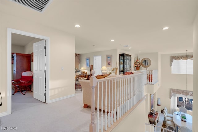 hall featuring light colored carpet