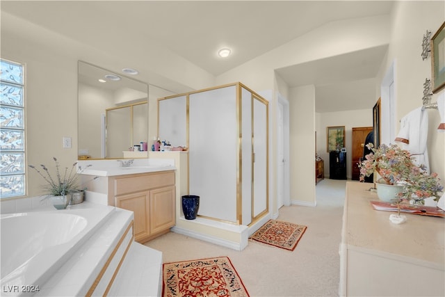 bathroom with shower with separate bathtub, vaulted ceiling, and vanity