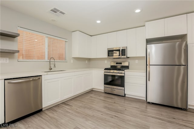 kitchen featuring light hardwood / wood-style flooring, white cabinets, stainless steel appliances, and sink